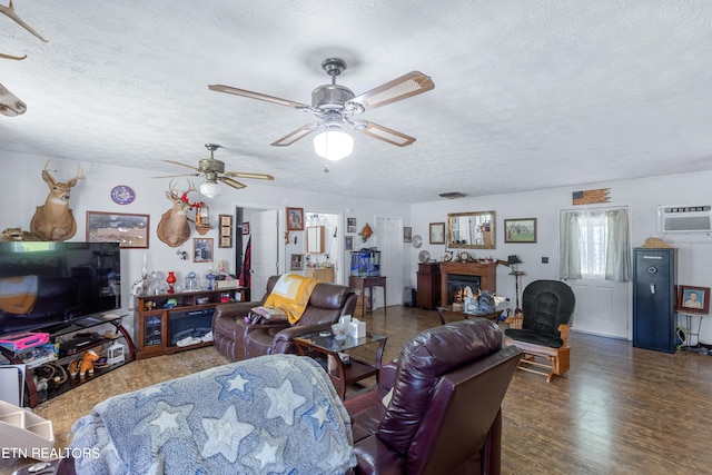 living room featuring dark hardwood / wood-style flooring, ceiling fan, a wall mounted AC, and a textured ceiling