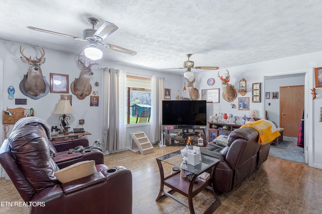 living room with wood-type flooring, a textured ceiling, and ceiling fan