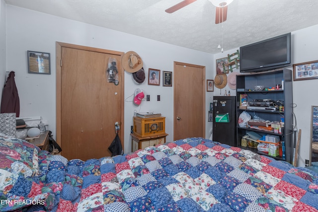 bedroom with ceiling fan and a textured ceiling