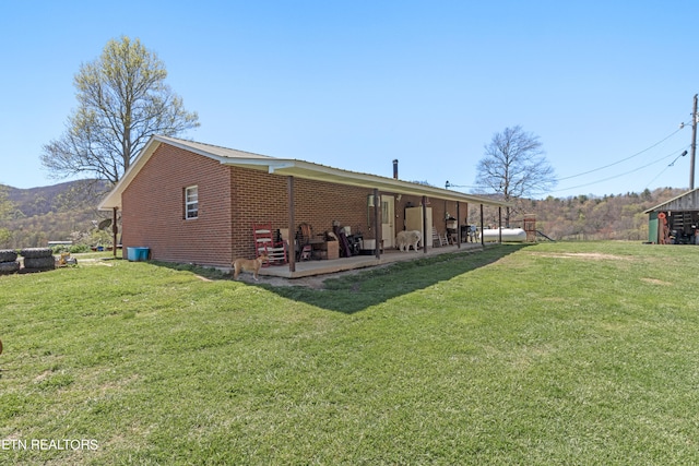 rear view of house with a yard and a patio area