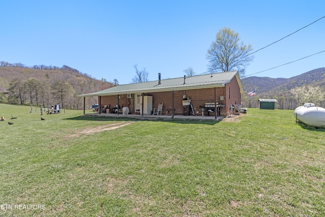 back of property featuring a mountain view and a yard