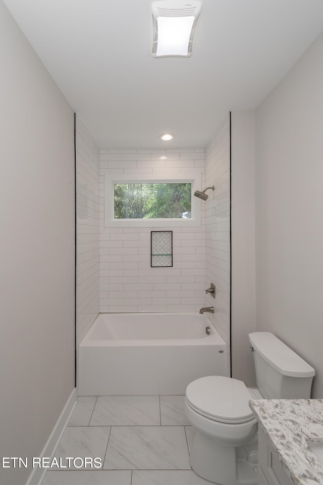 full bathroom with tiled shower / bath, vanity, and toilet