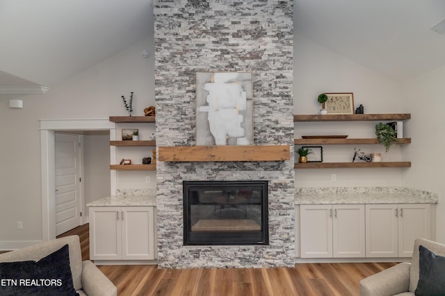 living room featuring light hardwood / wood-style flooring, a fireplace, and high vaulted ceiling