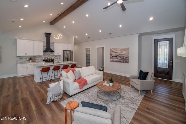 living room featuring high vaulted ceiling, beamed ceiling, sink, dark hardwood / wood-style flooring, and ceiling fan