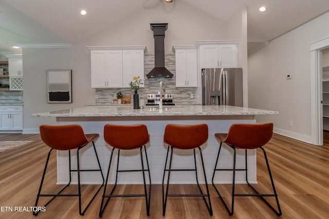 kitchen with white cabinetry, wall chimney range hood, a kitchen island with sink, and stainless steel appliances