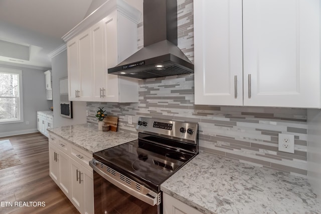 kitchen with range hood, white cabinets, stainless steel range with electric cooktop, decorative backsplash, and light stone countertops