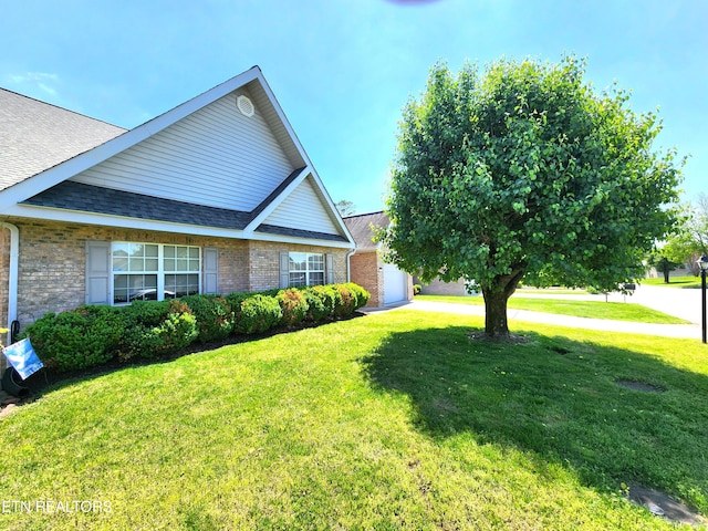 view of side of home with a yard and a garage