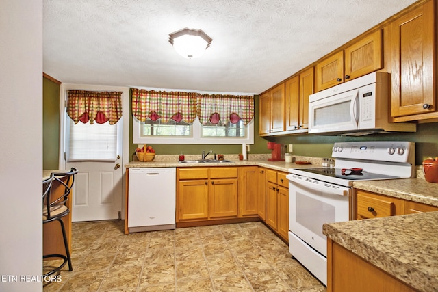 kitchen featuring sink, white appliances, light tile flooring, and a textured ceiling