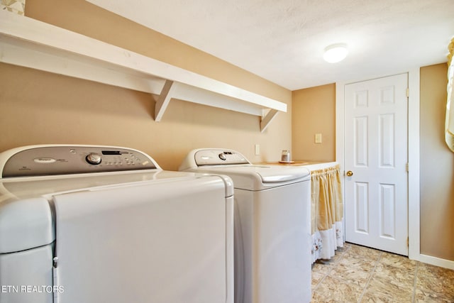 clothes washing area with light tile floors and washer and clothes dryer