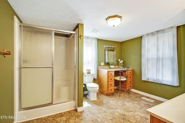 bathroom featuring a shower with shower door, vanity, toilet, and tile flooring