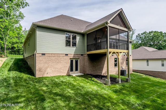 rear view of house featuring french doors, central AC unit, a yard, and a sunroom