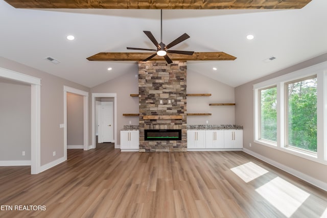 unfurnished living room with a fireplace, light wood-type flooring, ceiling fan, and vaulted ceiling with beams