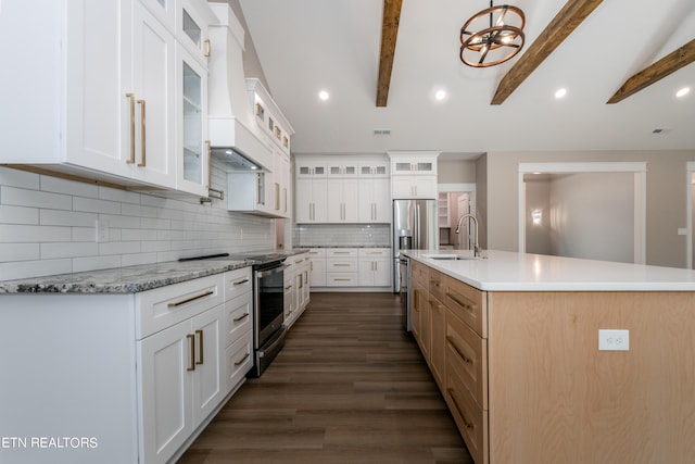 kitchen featuring a large island with sink, beamed ceiling, white cabinets, backsplash, and sink