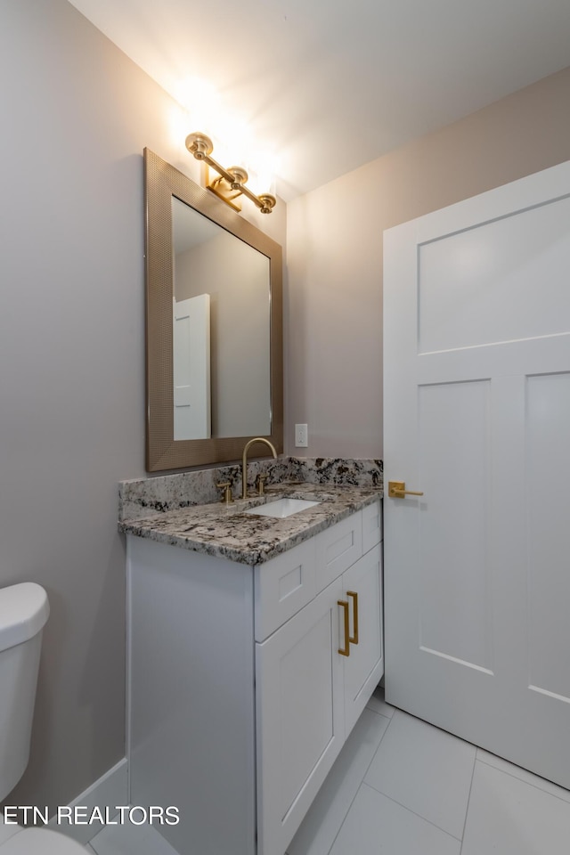 bathroom with toilet, tile patterned floors, and vanity