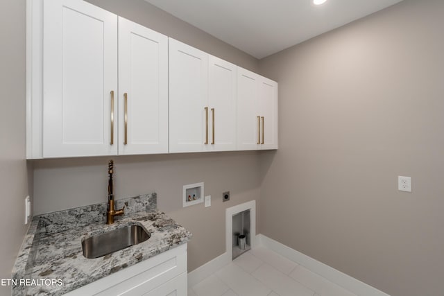 laundry room with cabinets, hookup for a washing machine, electric dryer hookup, sink, and light tile patterned flooring