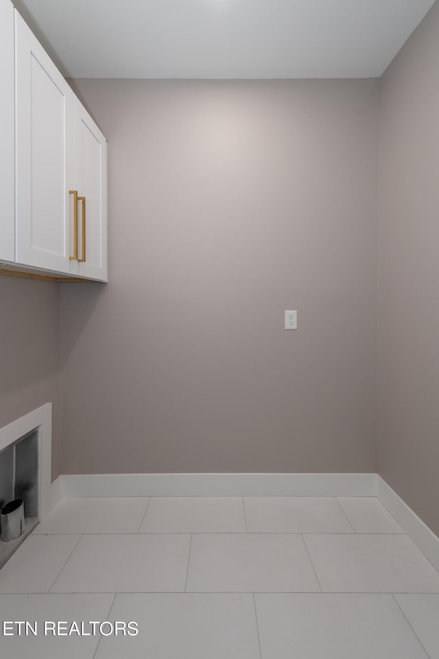 laundry area with cabinets and light tile patterned floors