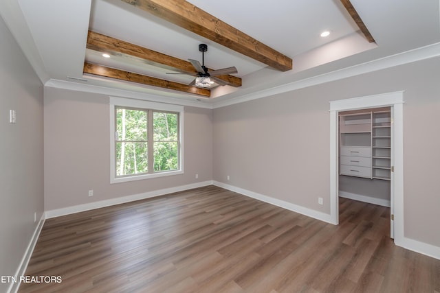 unfurnished room featuring ceiling fan, ornamental molding, dark hardwood / wood-style floors, and a tray ceiling