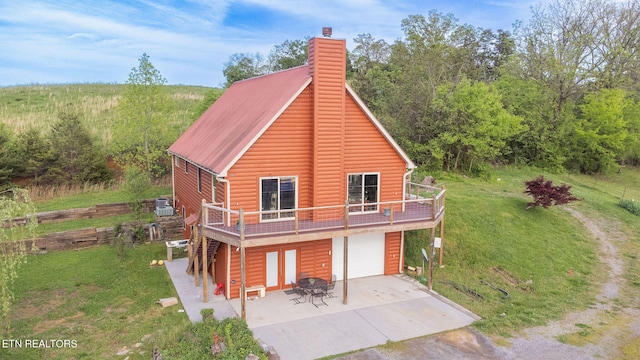 log-style house featuring a garage, central air condition unit, a patio, and a front lawn