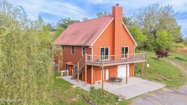 rear view of property with a garage and a lawn