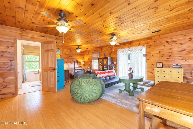 living room featuring wood ceiling, wood walls, ceiling fan, and light wood-type flooring