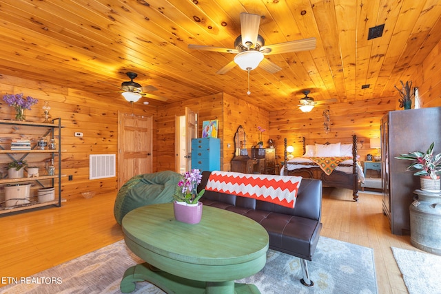 playroom with wood ceiling, wood walls, and light hardwood / wood-style flooring