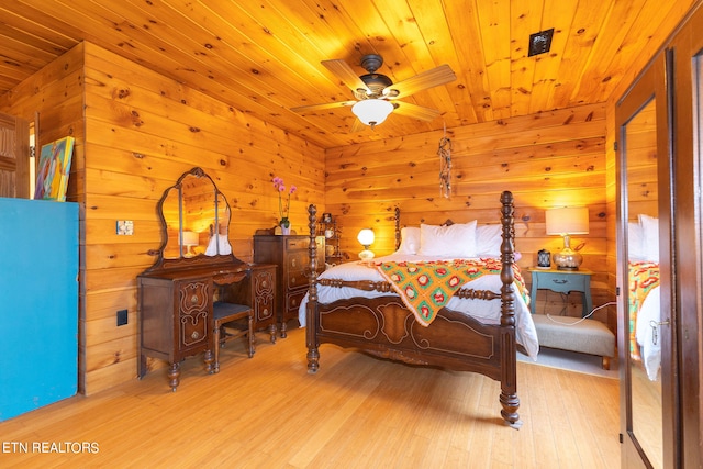 bedroom with wooden walls, light hardwood / wood-style floors, ceiling fan, and wooden ceiling