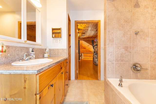 bathroom featuring a tub, vanity, and tile floors