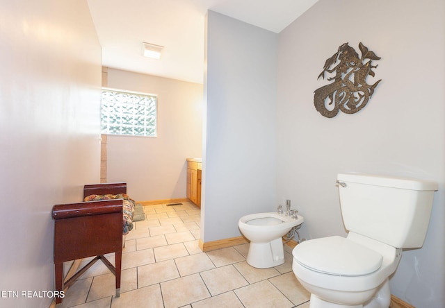 bathroom featuring vanity, toilet, a bidet, and tile flooring