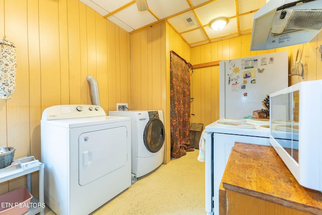 laundry room with wood walls, independent washer and dryer, and hookup for a washing machine