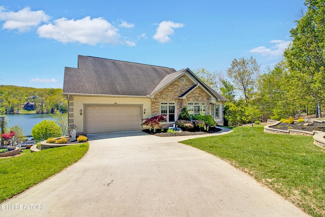 view of front facade with a front lawn, a garage, and a water view