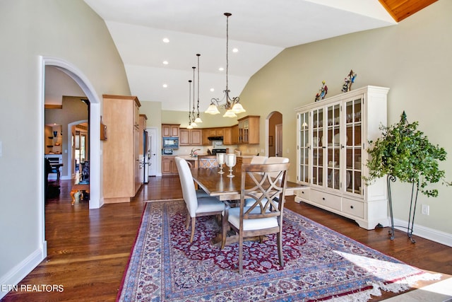 dining space featuring high vaulted ceiling, dark wood-type flooring, and sink