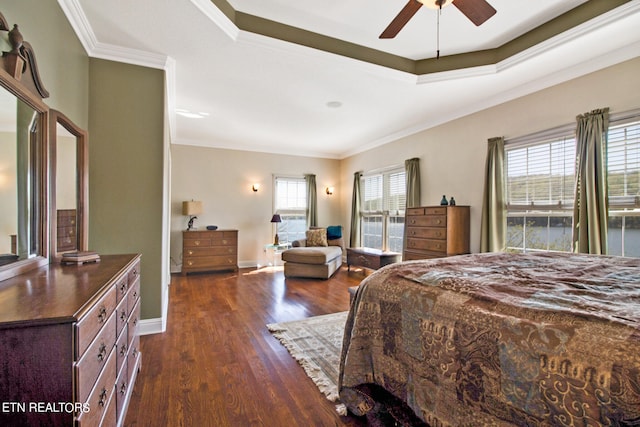 bedroom with ceiling fan, dark wood-type flooring, a tray ceiling, and ornamental molding