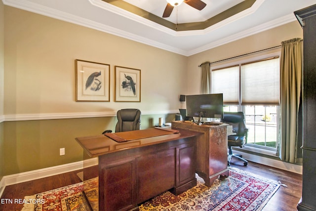 office space featuring ceiling fan, crown molding, a tray ceiling, and dark wood-type flooring