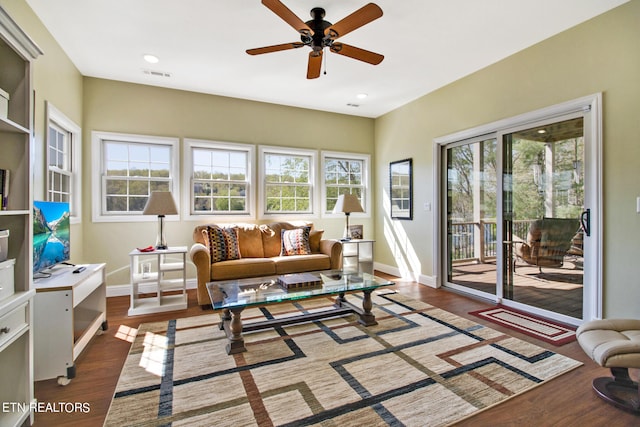 living room with ceiling fan, a wealth of natural light, and dark hardwood / wood-style flooring