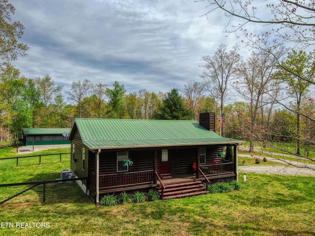 cabin featuring covered porch and a front lawn