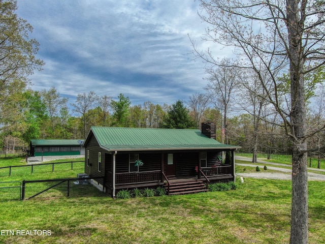 back of house featuring covered porch and a yard