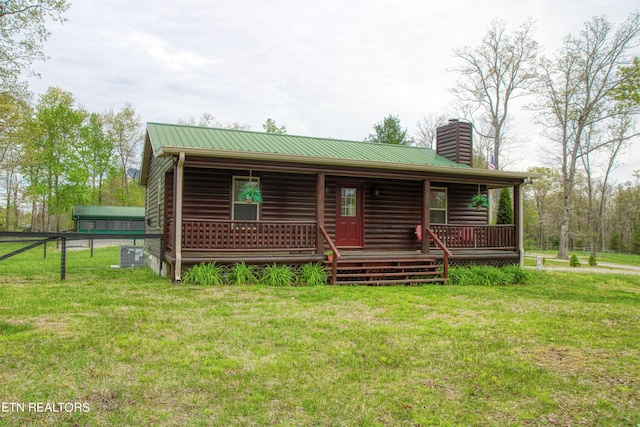 log home featuring a front yard, central air condition unit, and covered porch