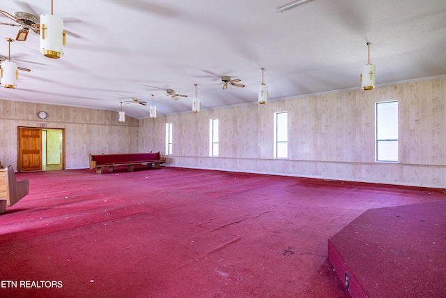 garage with ceiling fan and wooden walls