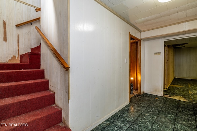 stairway featuring dark tile flooring