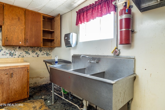 kitchen featuring a drop ceiling and sink