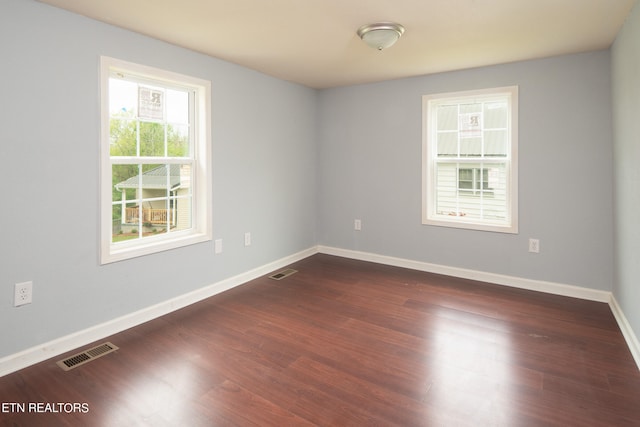 unfurnished room with dark hardwood / wood-style flooring