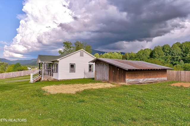 back of house featuring a lawn and a mountain view