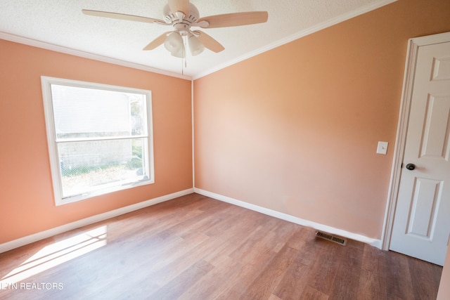 spare room featuring ornamental molding, wood-type flooring, ceiling fan, and a textured ceiling