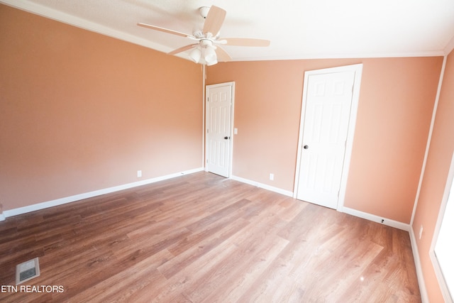 empty room with lofted ceiling, ceiling fan, and hardwood / wood-style flooring