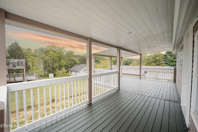 deck at dusk featuring a yard