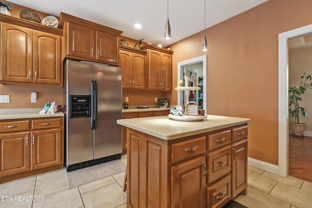 57 Inwood Ter, Crossville, TN 38558 - kitchen featuring light countertops, stainless steel fridge with ice dispenser, brown cabinetry, light tile patterned floors, and decorative light fixtures