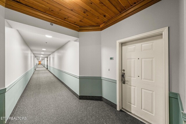 corridor with wood ceiling, carpet flooring, and ornamental molding