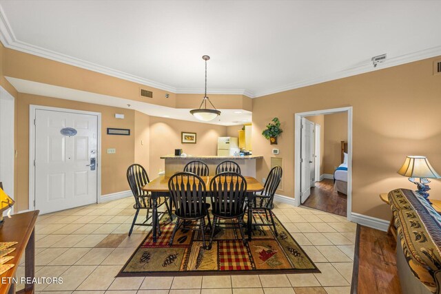 dining room featuring light hardwood / wood-style flooring and crown molding