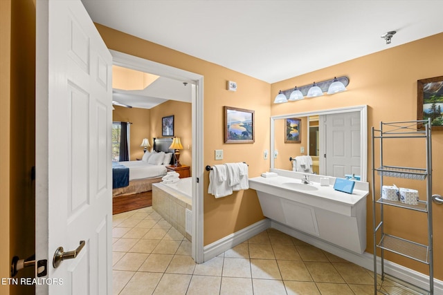 bathroom featuring tile flooring, vanity, and a bath