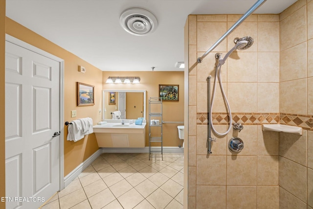 bathroom with tile floors, toilet, sink, and a tile shower